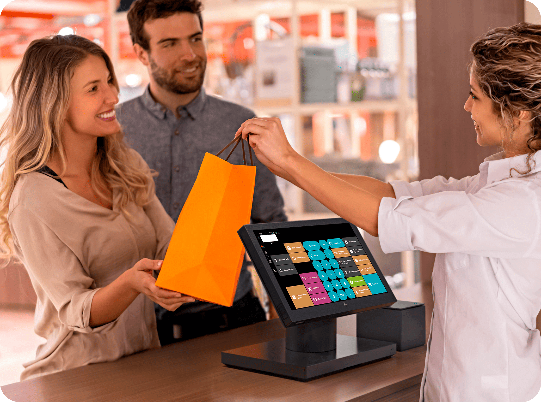 A cashier checking out happy customers using a touch screen pos system with a built in loyalty program