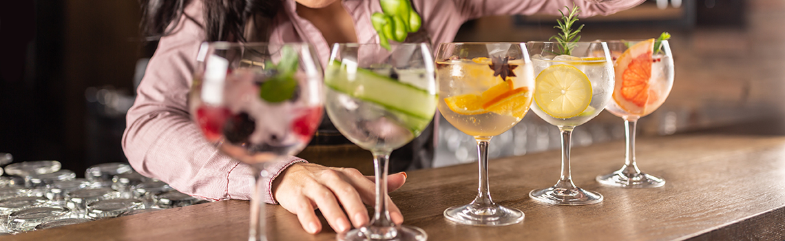 Bartender preparing colorful cocktails with fresh garnishes