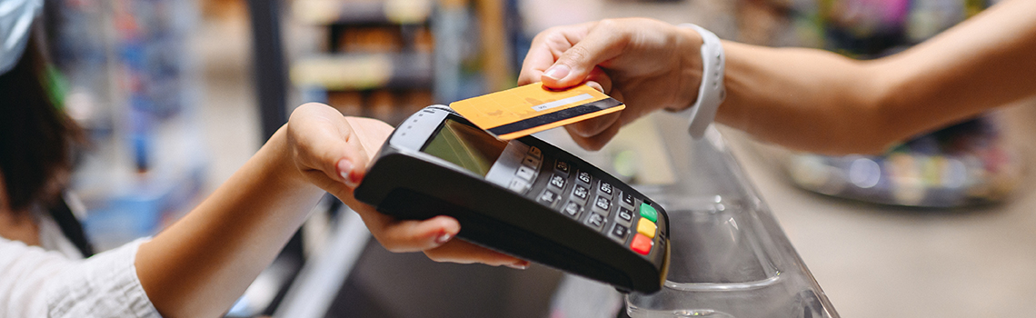 Customer making a contactless payment with a credit card at checkout