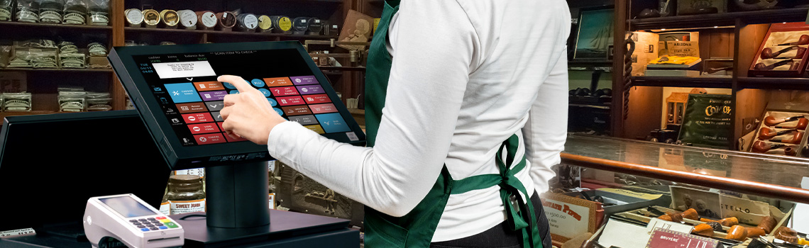 Cashier using a touchscreen POS system in a retail store 