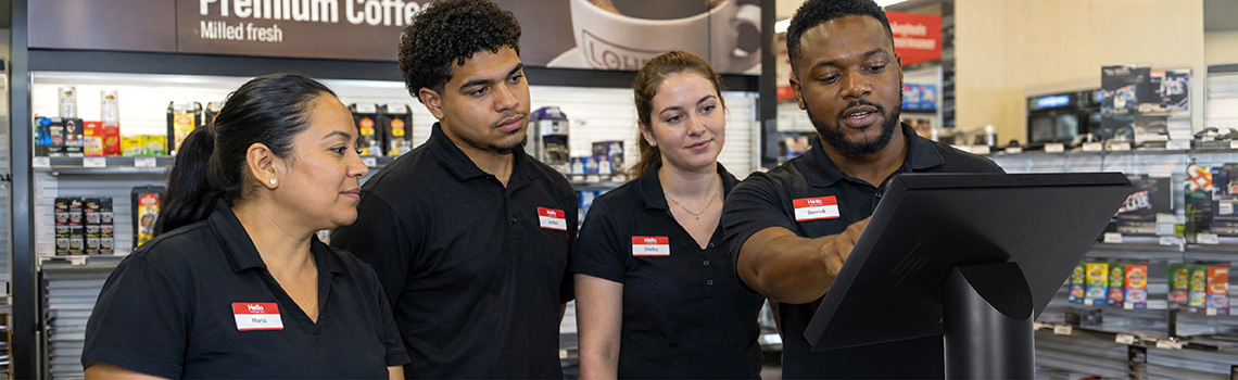 Staff Using a POS System Inside a Convenience Store 